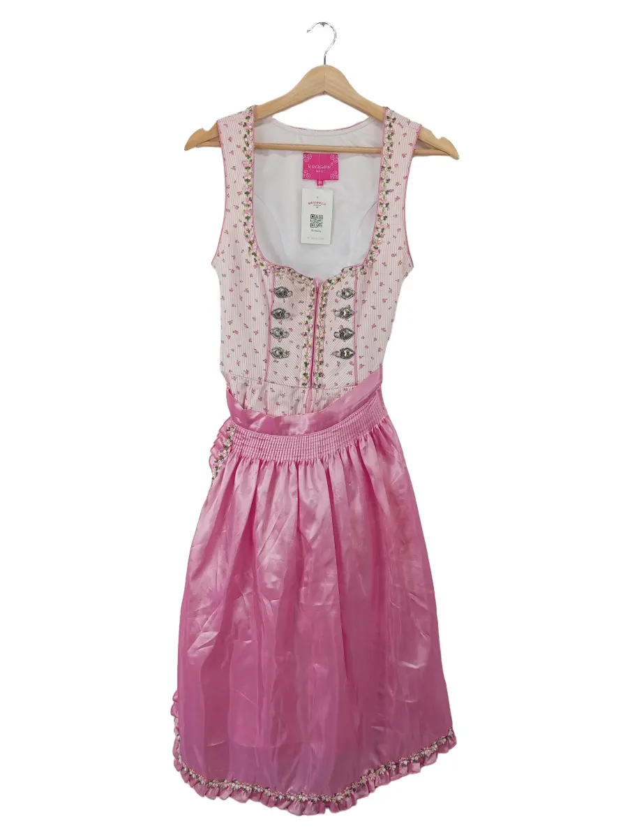 Rosa Dirndl mit gemustertem Oberteil und Schürze auf einem Bügel